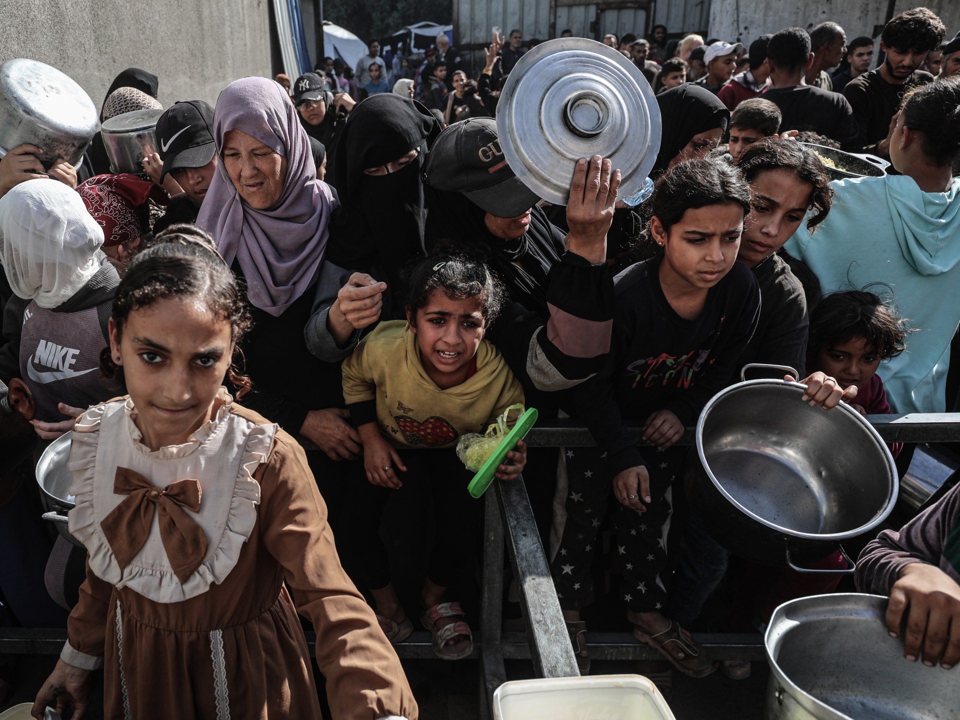 Người Palestine chờ nhận bữa ăn được ph&acirc;n ph&aacute;t bởi một tổ chức từ thiện tại trại tị nạn Nuseirat, miền trung Gaza.