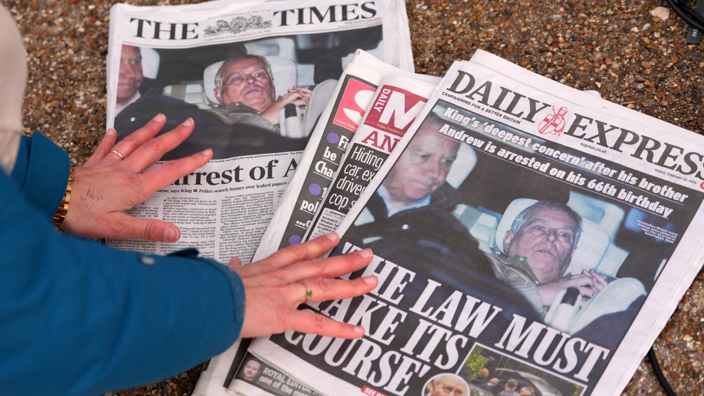 Một nh&agrave; b&aacute;o xem trang nhất b&aacute;o ch&iacute; London sau khi Andrew Mountbatten-Windsor bị bắt giữ